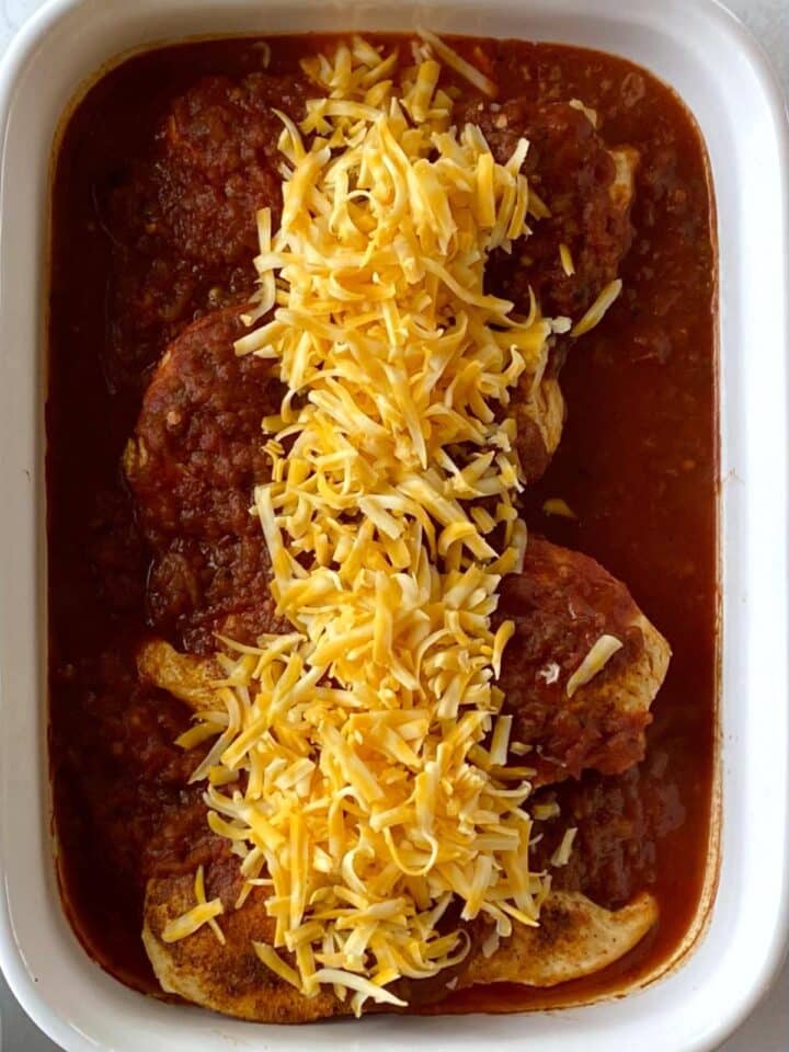 Baked chicken topped with shredded cheese.