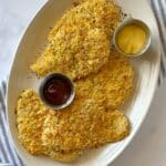 Club cracker chicken with dipping sauces on a platter.