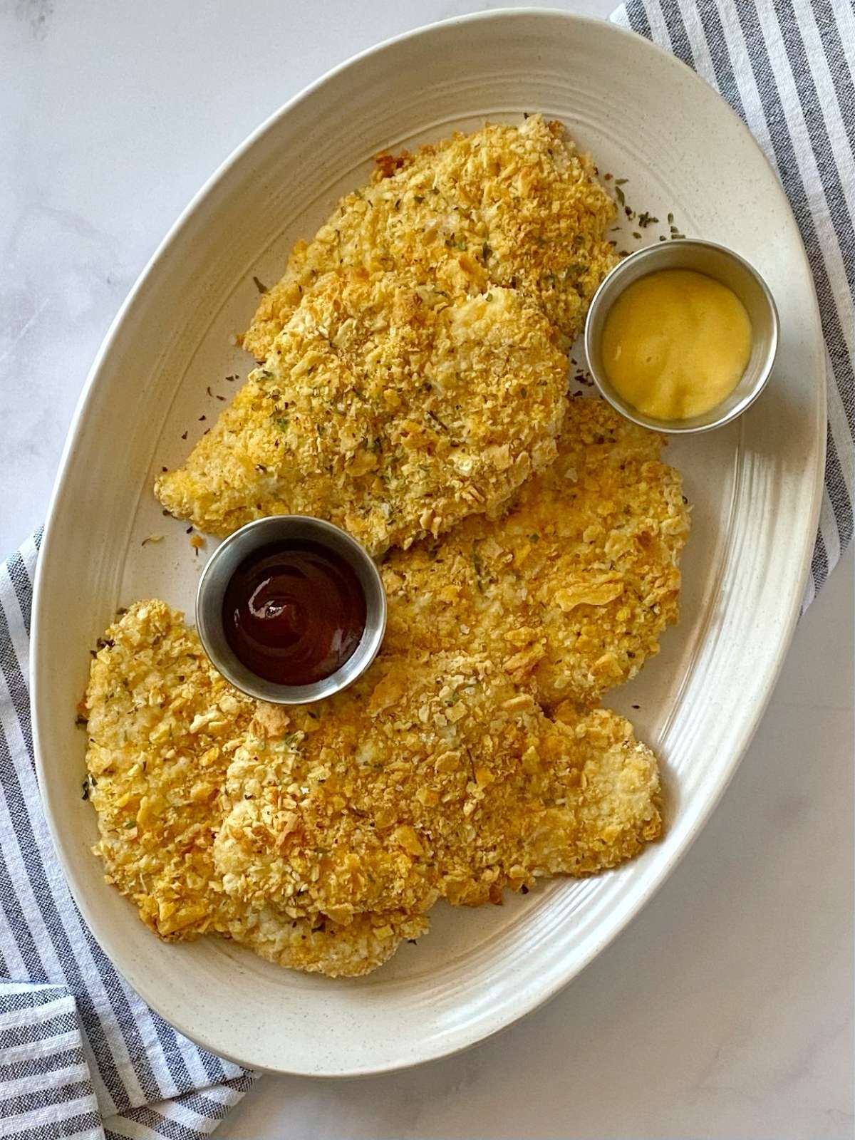 baked crispy chicken cutlets on a platter.