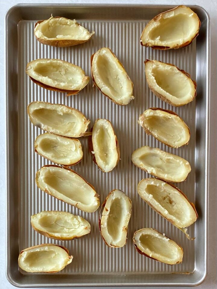 Scooped out potato shells on a sheet pan.