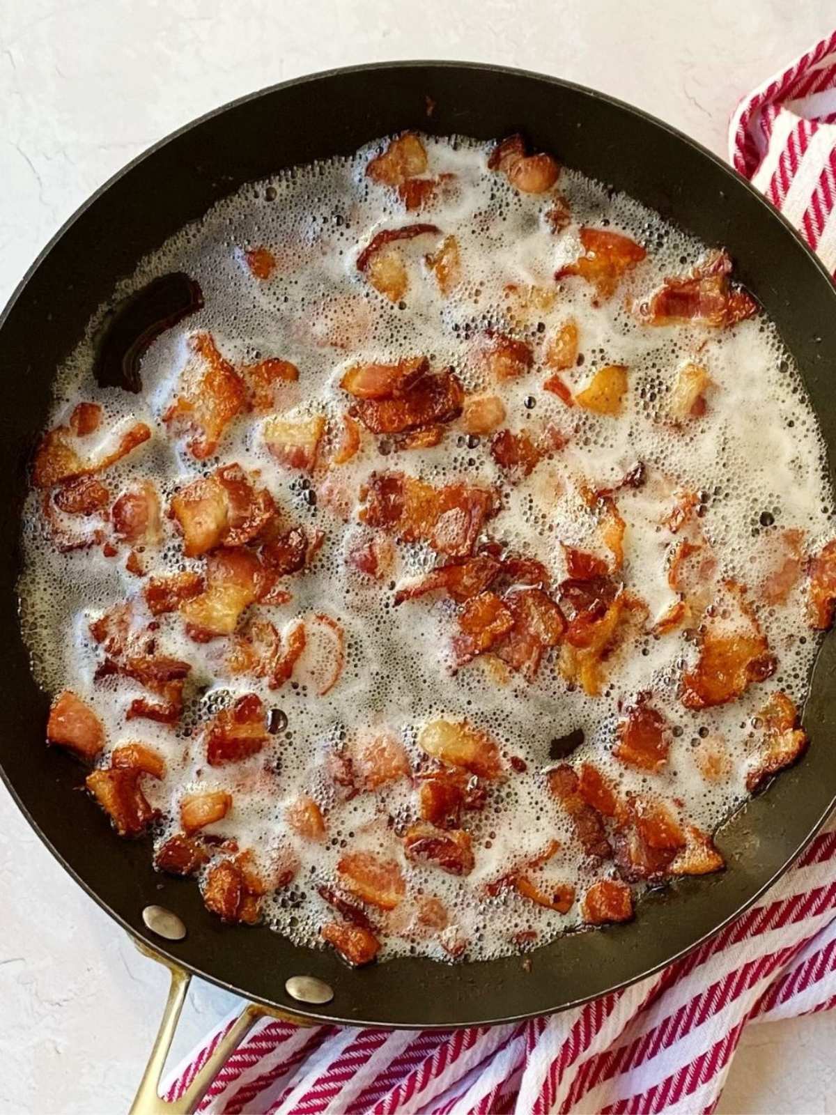 Bacon cooking in a skillet.