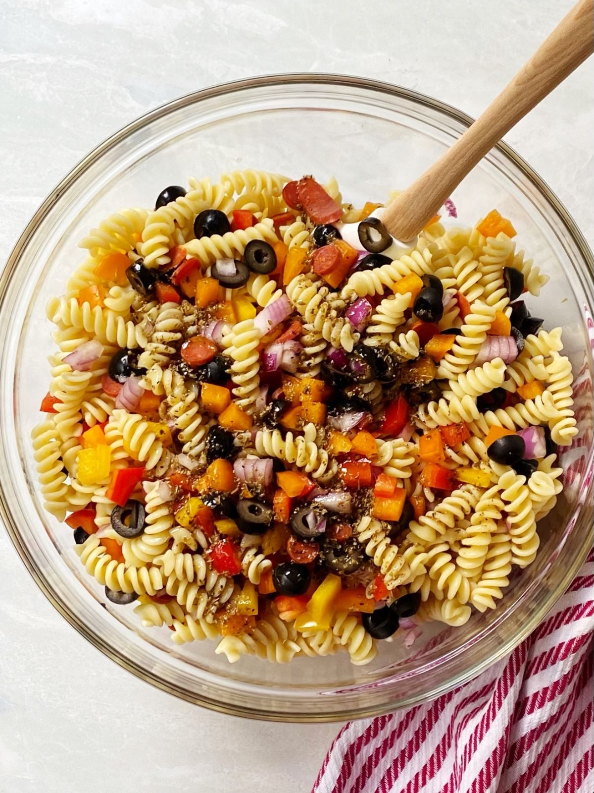 Bowl of pasta salad ingredients mixed together.
