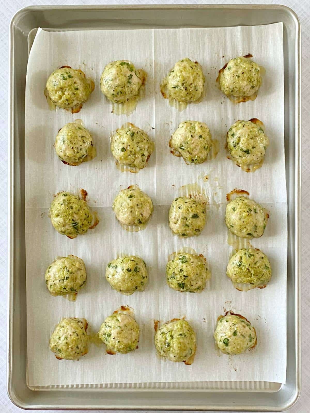 Cooked meatballs on a sheet pan.