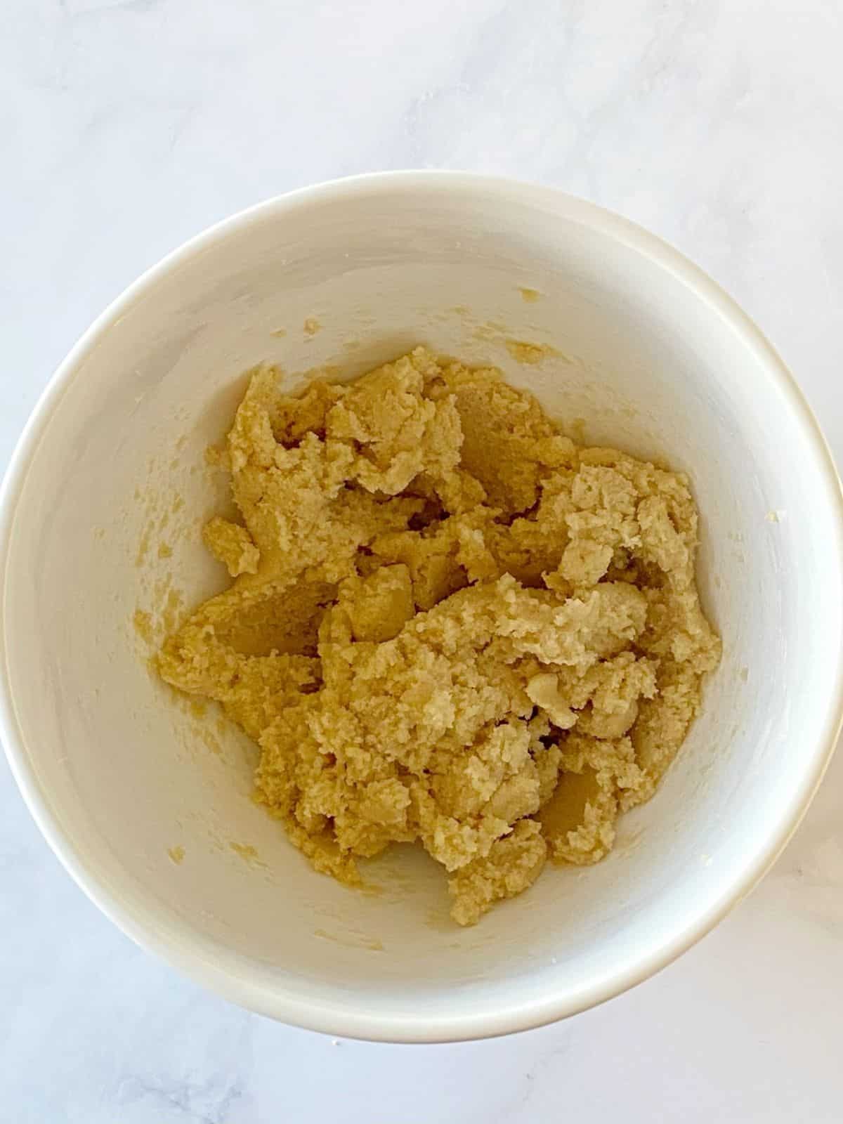 Butter and sugars creamed together in a mixing bowl.