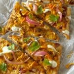 Flatbread topped with garnishes and sliced in triangles.