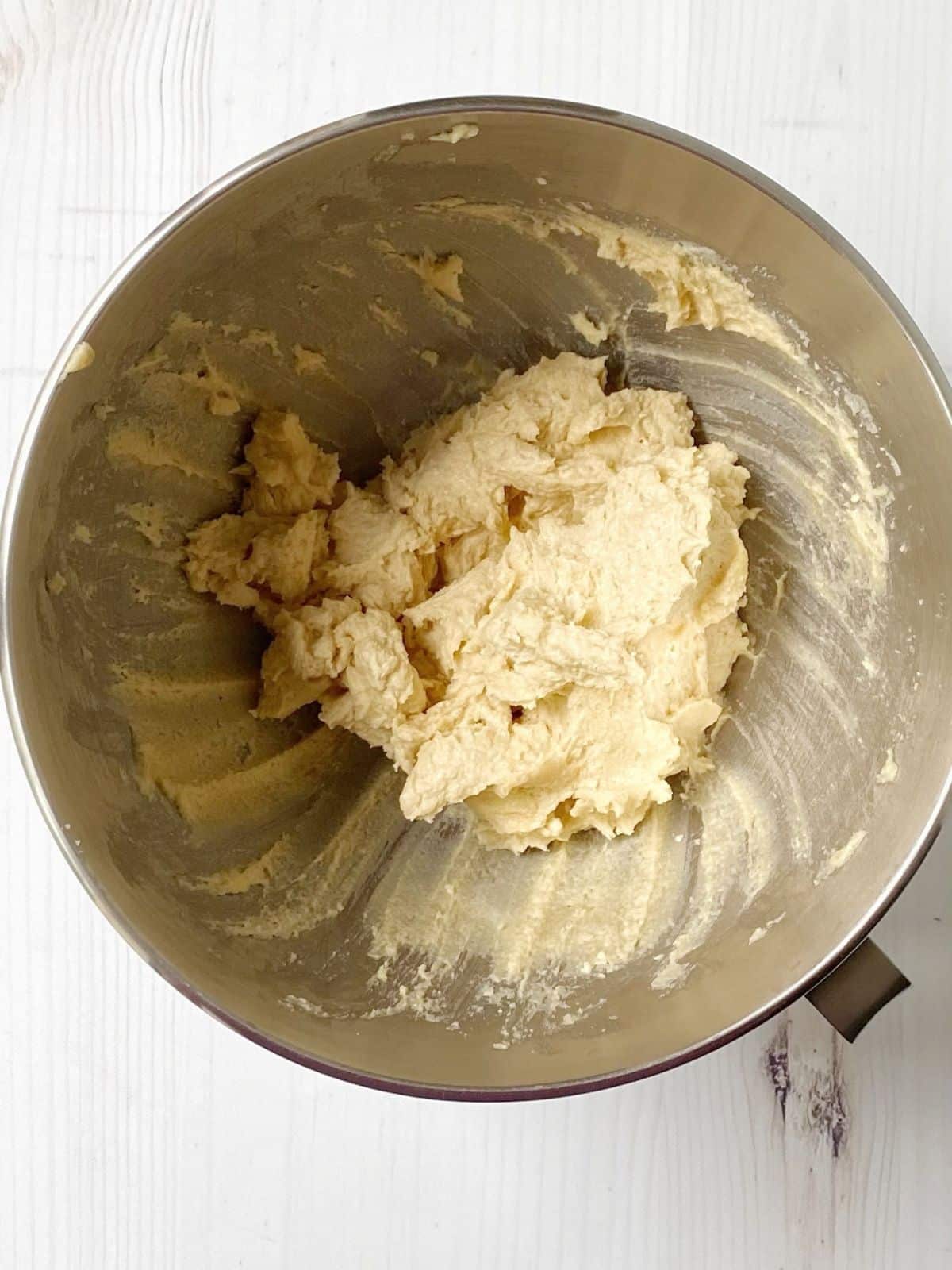 Butter, sugar, eggs, and vanilla blended together in a mixing bowl.
