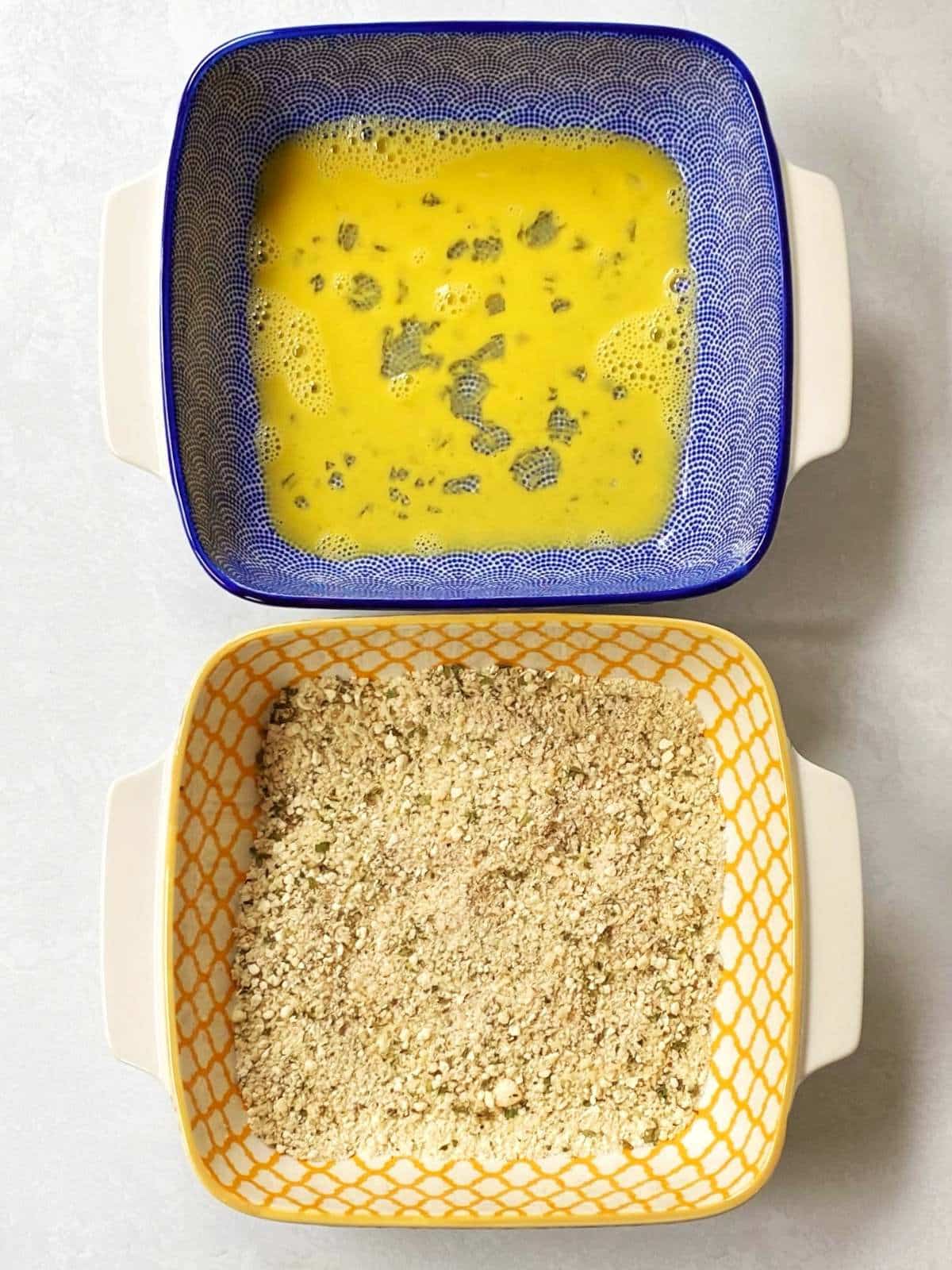 Shallow dishes containing beaten eggs and breadcrumb mixture.