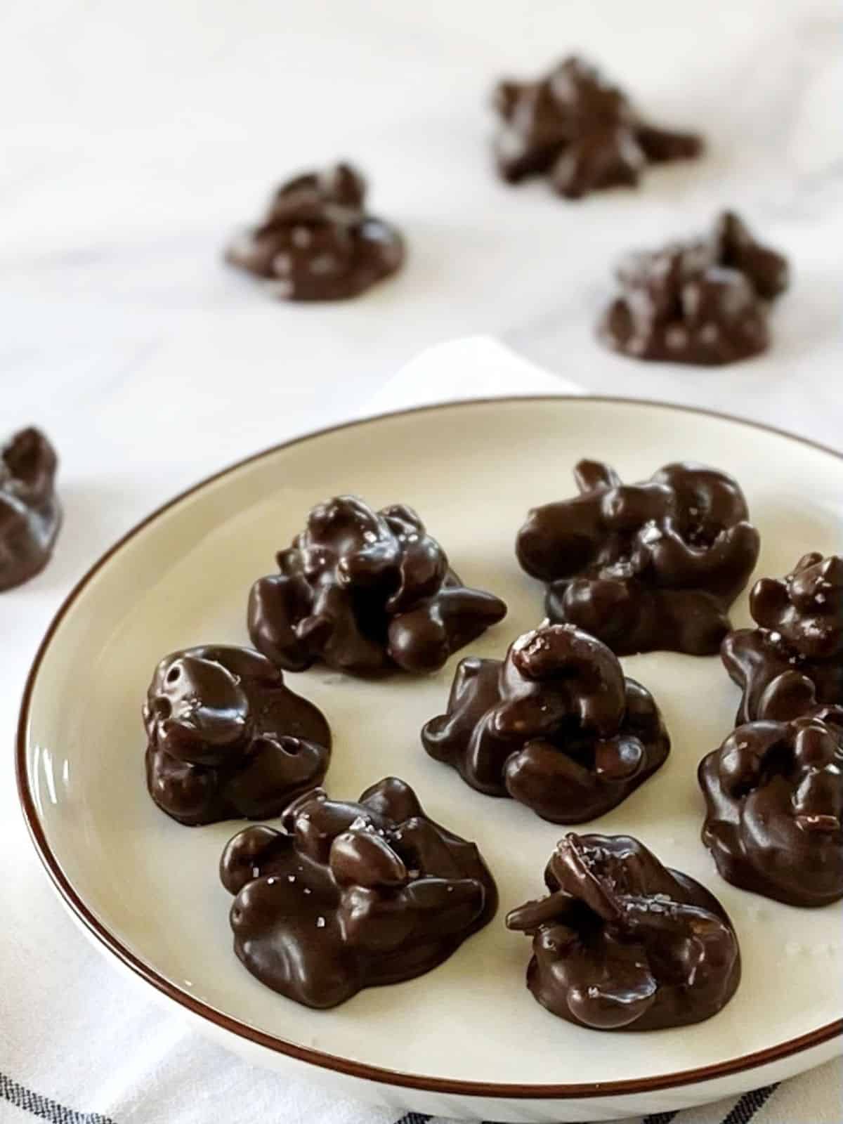 Chocolate-covered nut clusters on a plate.