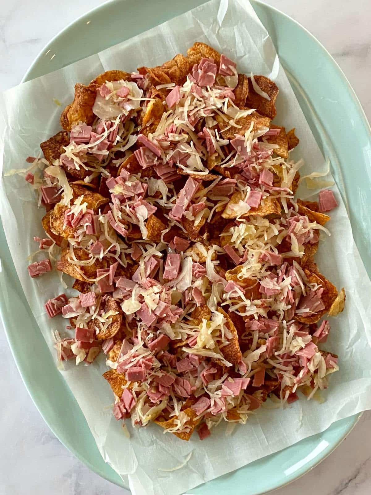 Platter of potato chips topped with corned beef and sauerkraut.