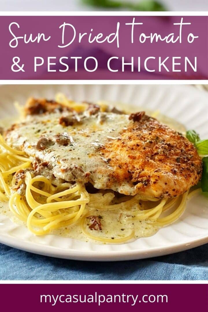 A plate of chicken with pesto and sun-dried tomatoes over pasta.