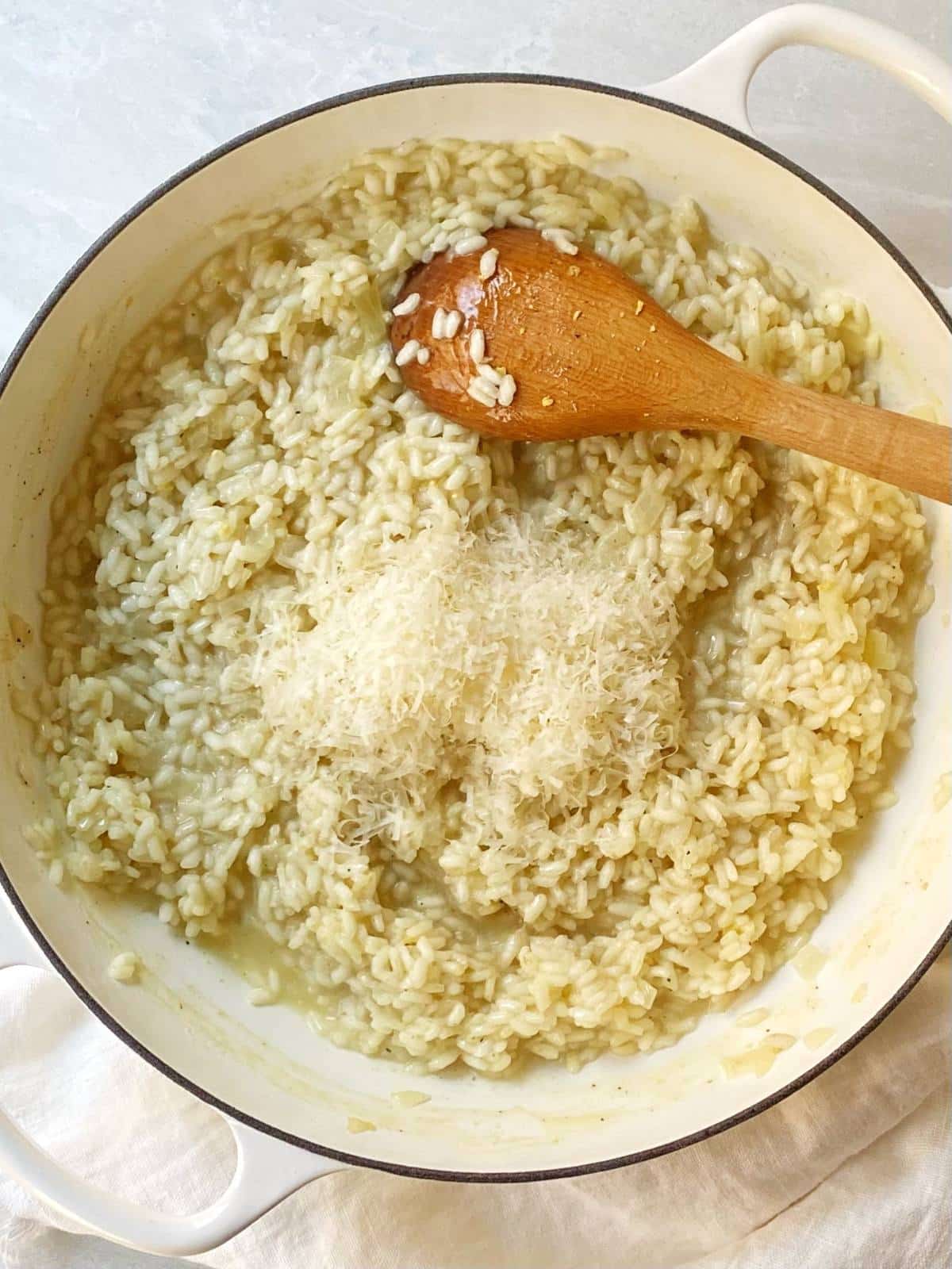 Stirring Parmesan cheese into the cooked risotto.