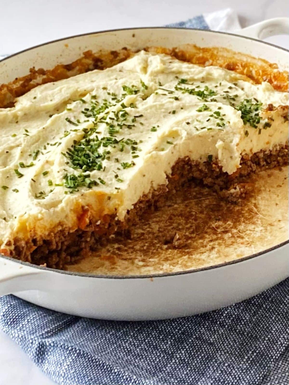 Partially eaten casserole dish of meat and potatoes.