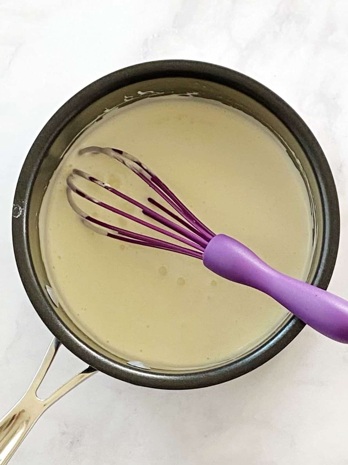 Milk and cream cheese combined in a saucepan.