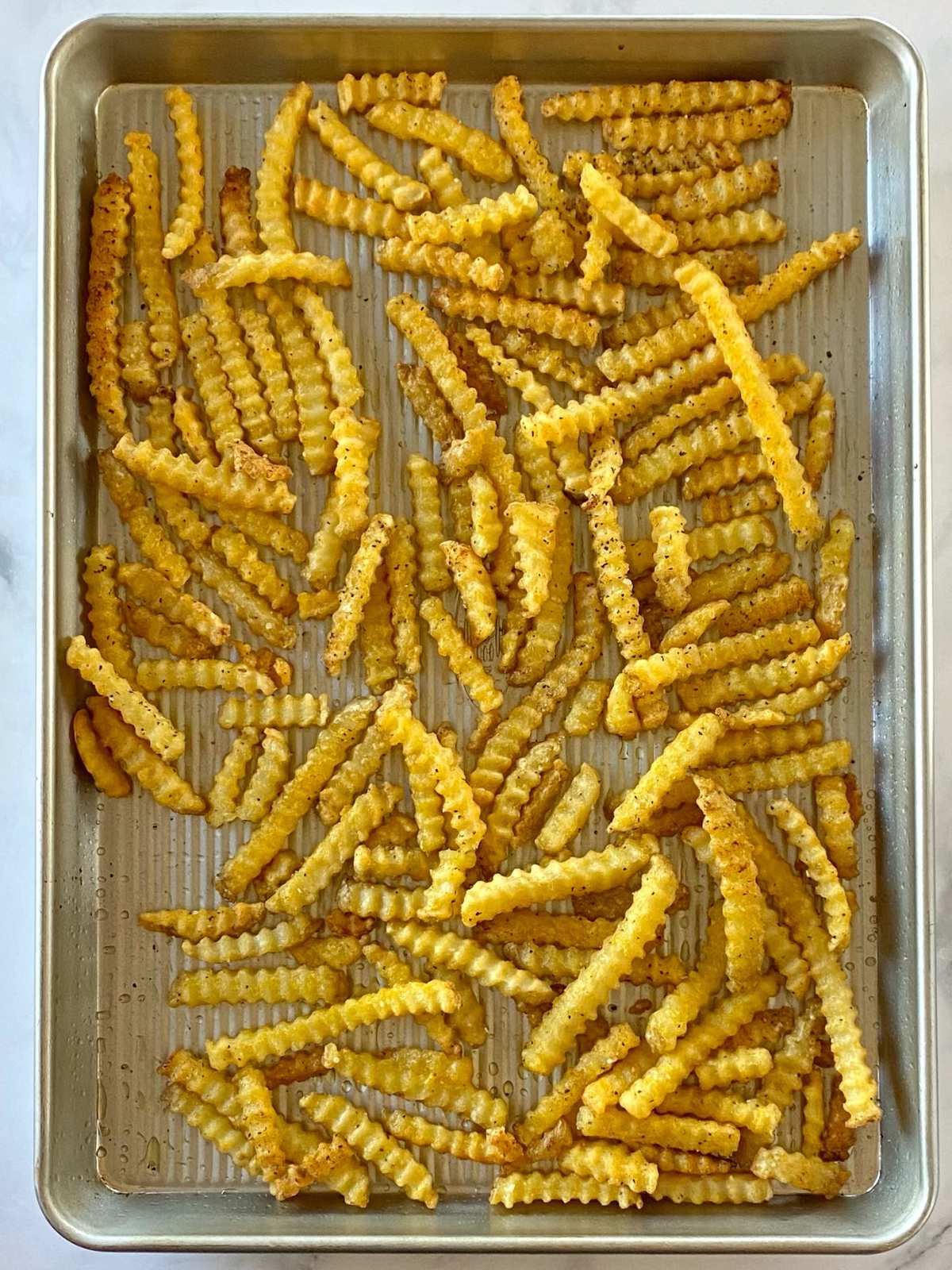 Baked french fries on a sheet pan.