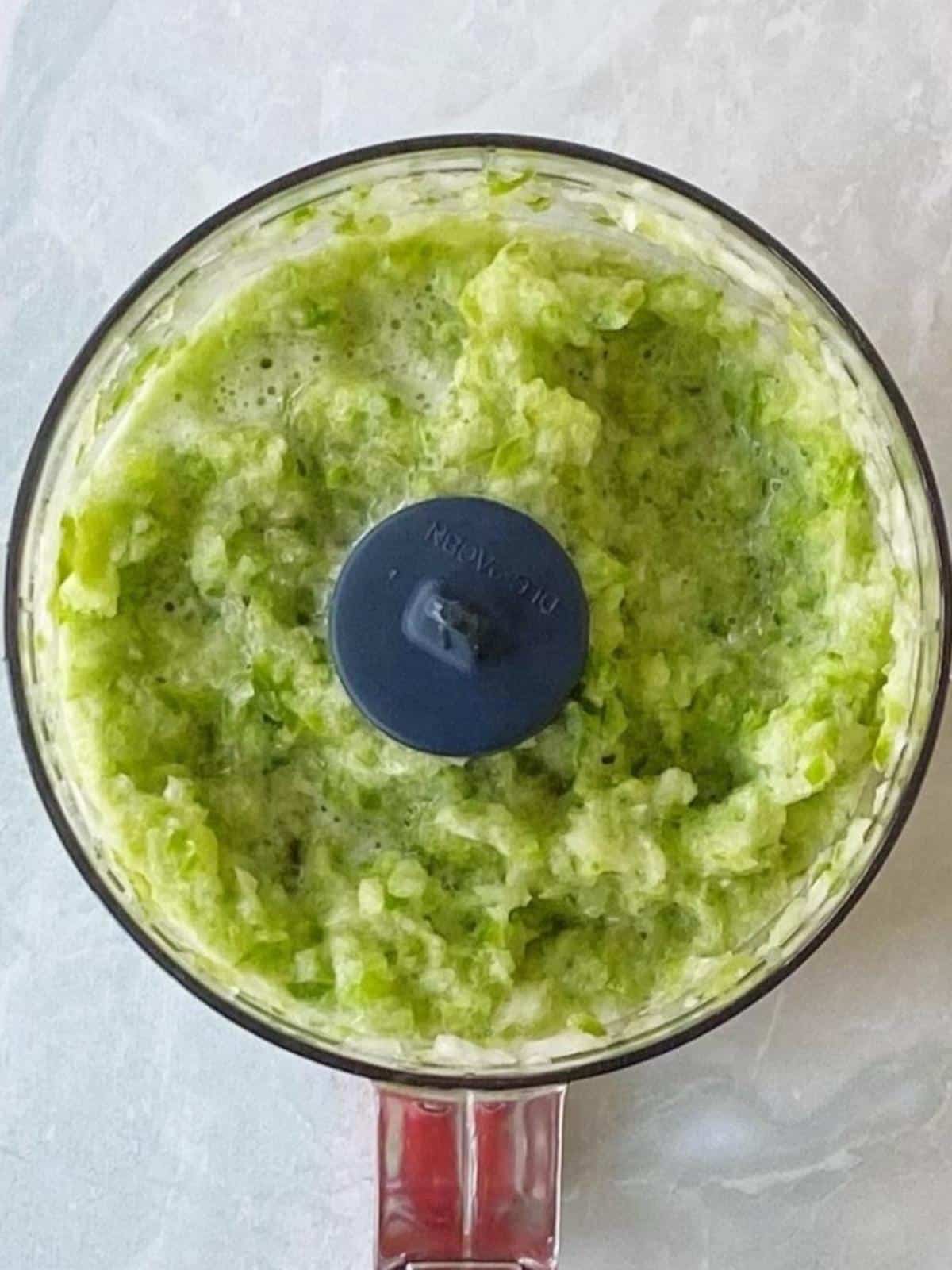 Pureed peppers and onions in a food processor bowl.