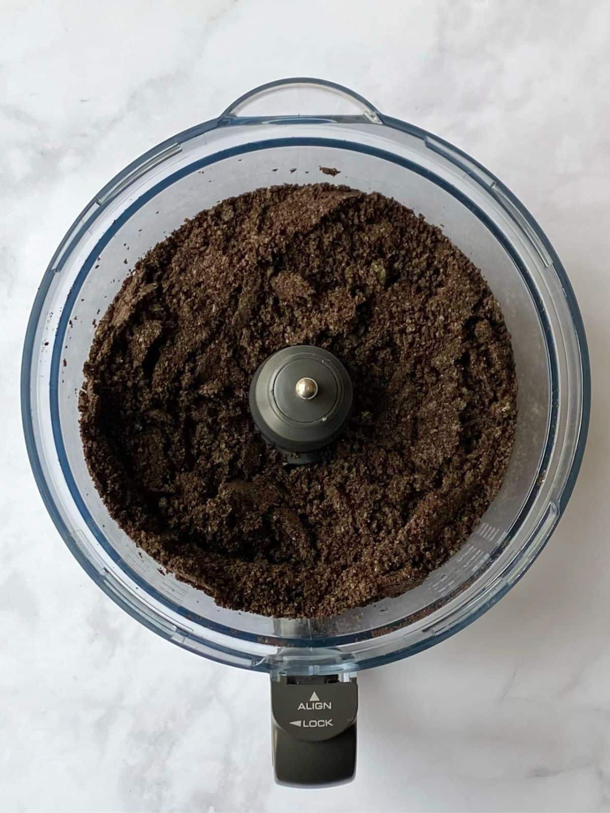 Oreo cookies processed into crumbs in a food processor.