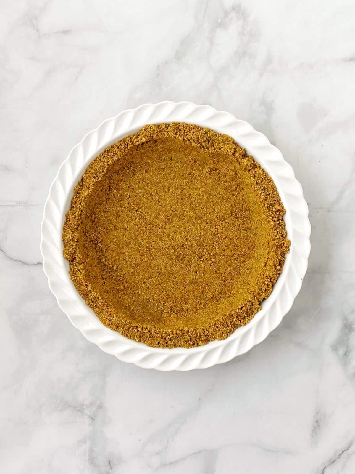 Nut and butter mixture pressed into a pie dish.