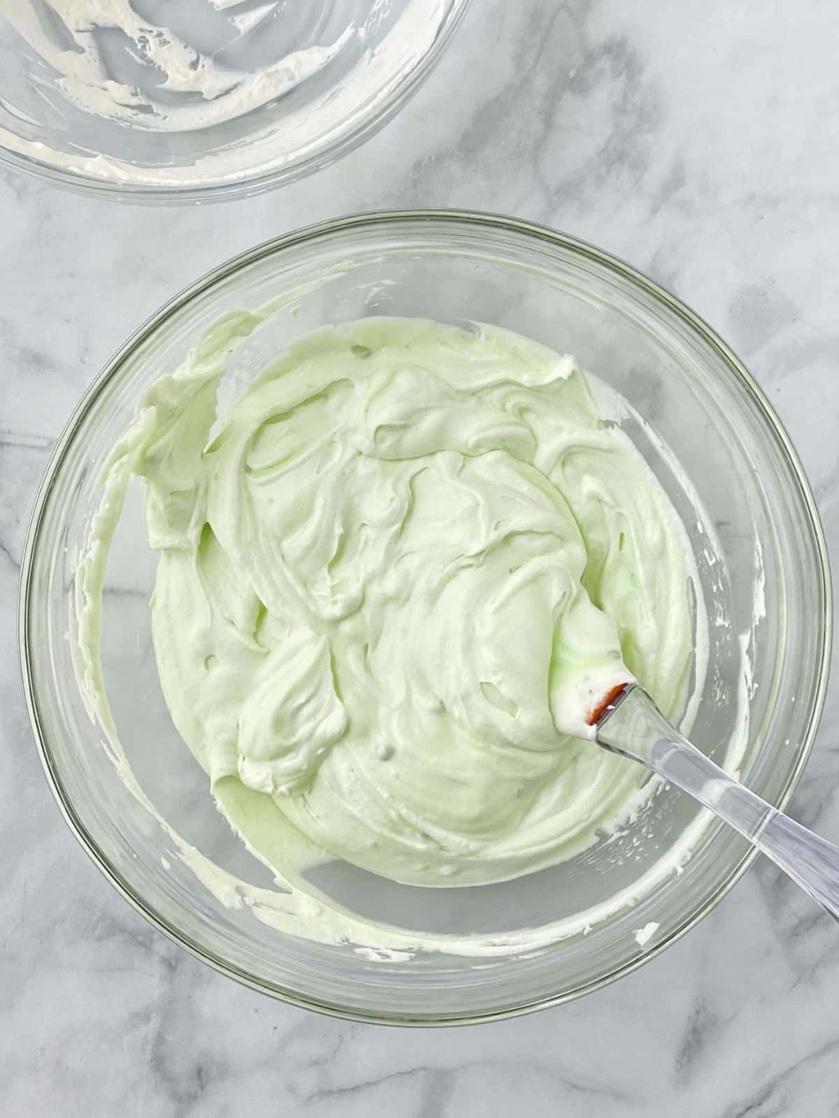 Pudding mixture and whipped cream blended together in a mixing bowl.