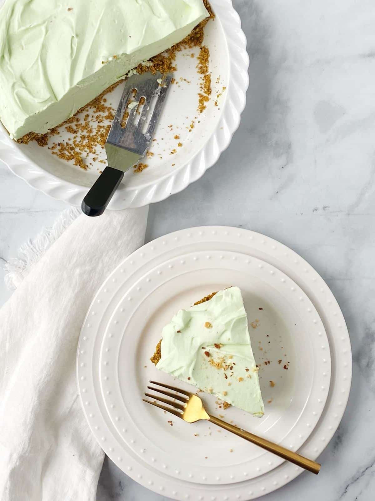 A slice of pie on a plate next to the partially empty pie plate.