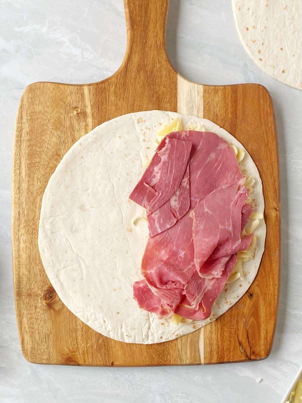 Tortilla topped with cheese and corned beef.