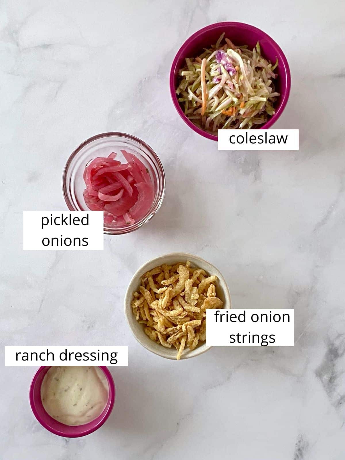 Toppings for sliders including coleslaw, pickled onions, fried onion strings, and ranch dressing.