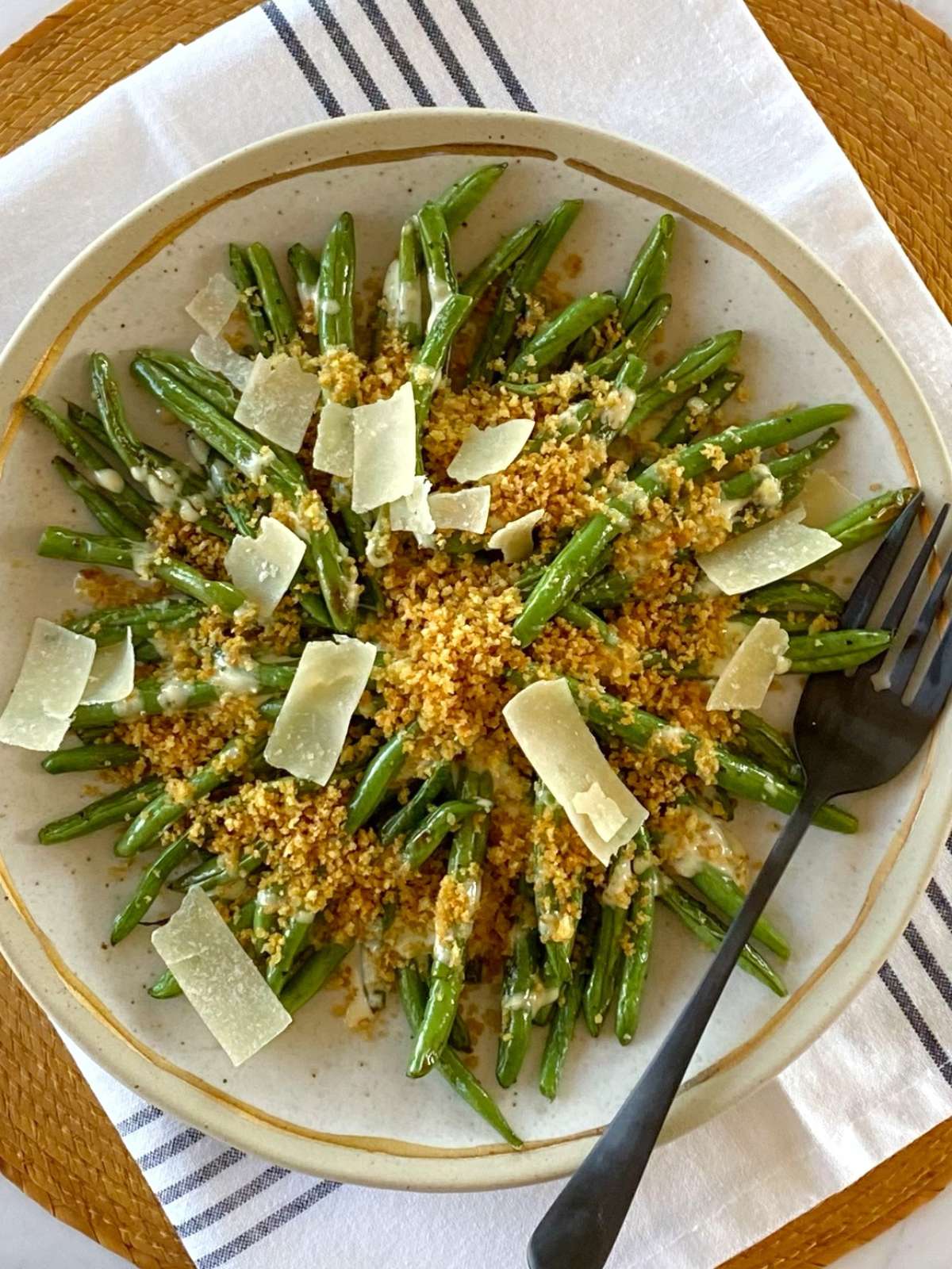 Beans topped with dressing and breadcrumbs on a serving platter.