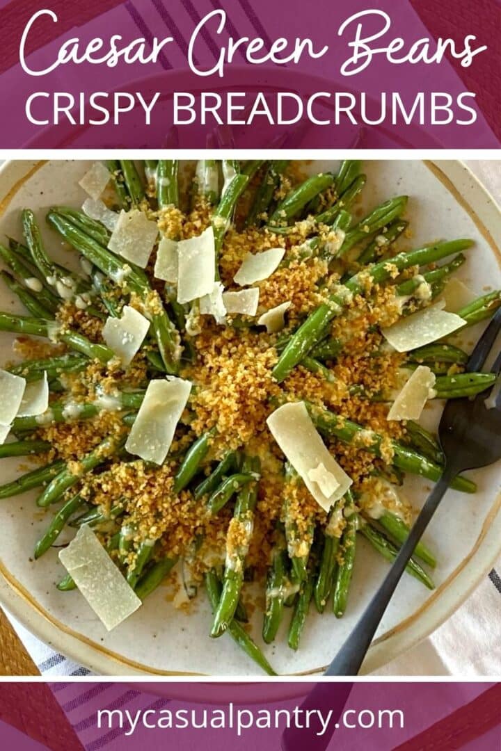Green beans with dressing and breadcrumbs on a platter.