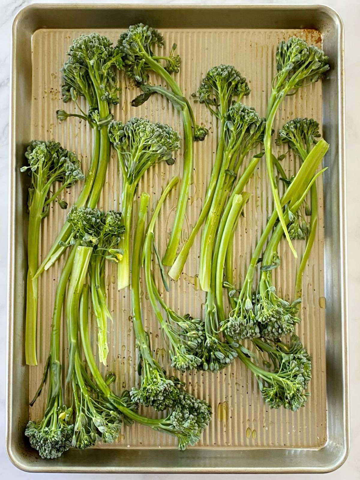 Broccolini on a sheet pan before roasting.