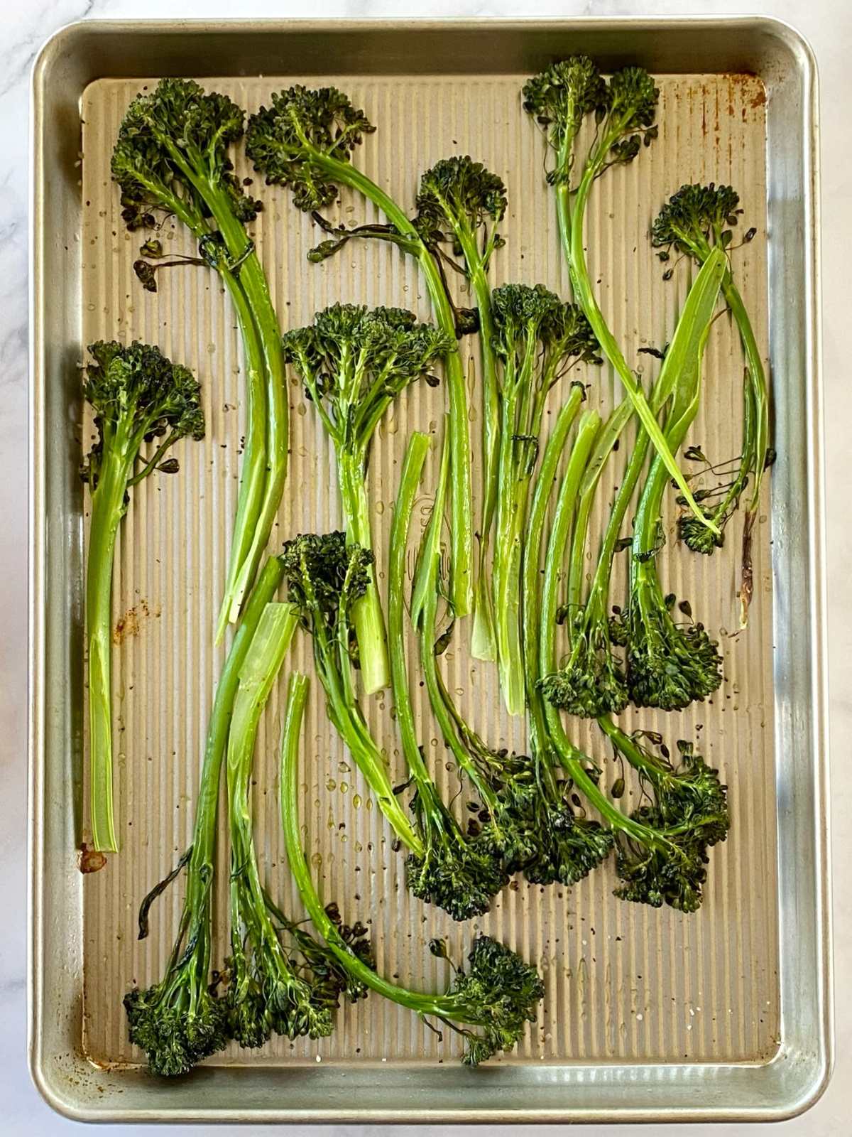 Broccolini on a sheet pan after roasting.