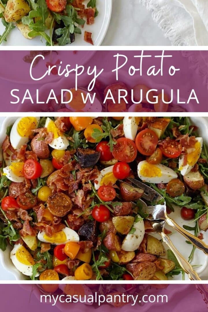 Potato and arugula salad on a serving platter next to a plate of salad.
