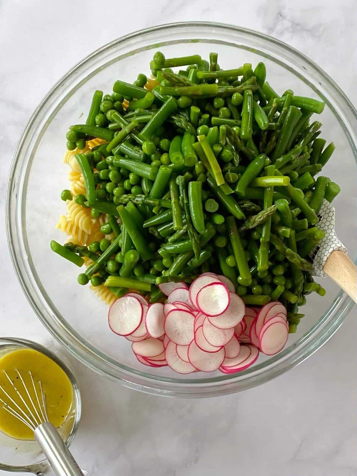 Pasta and veggies in a mixing bowl.