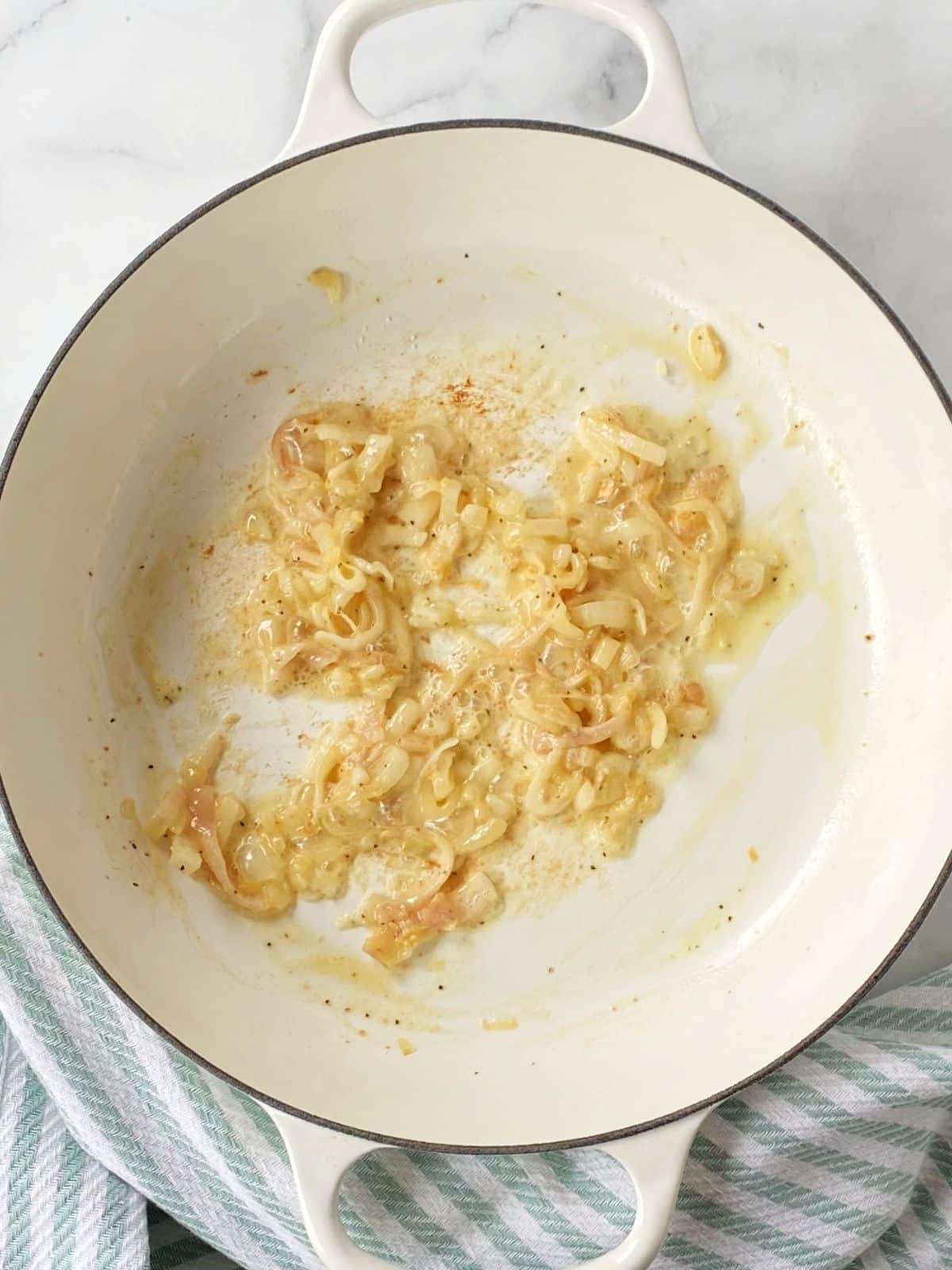 A skillet of shallots with flour added.