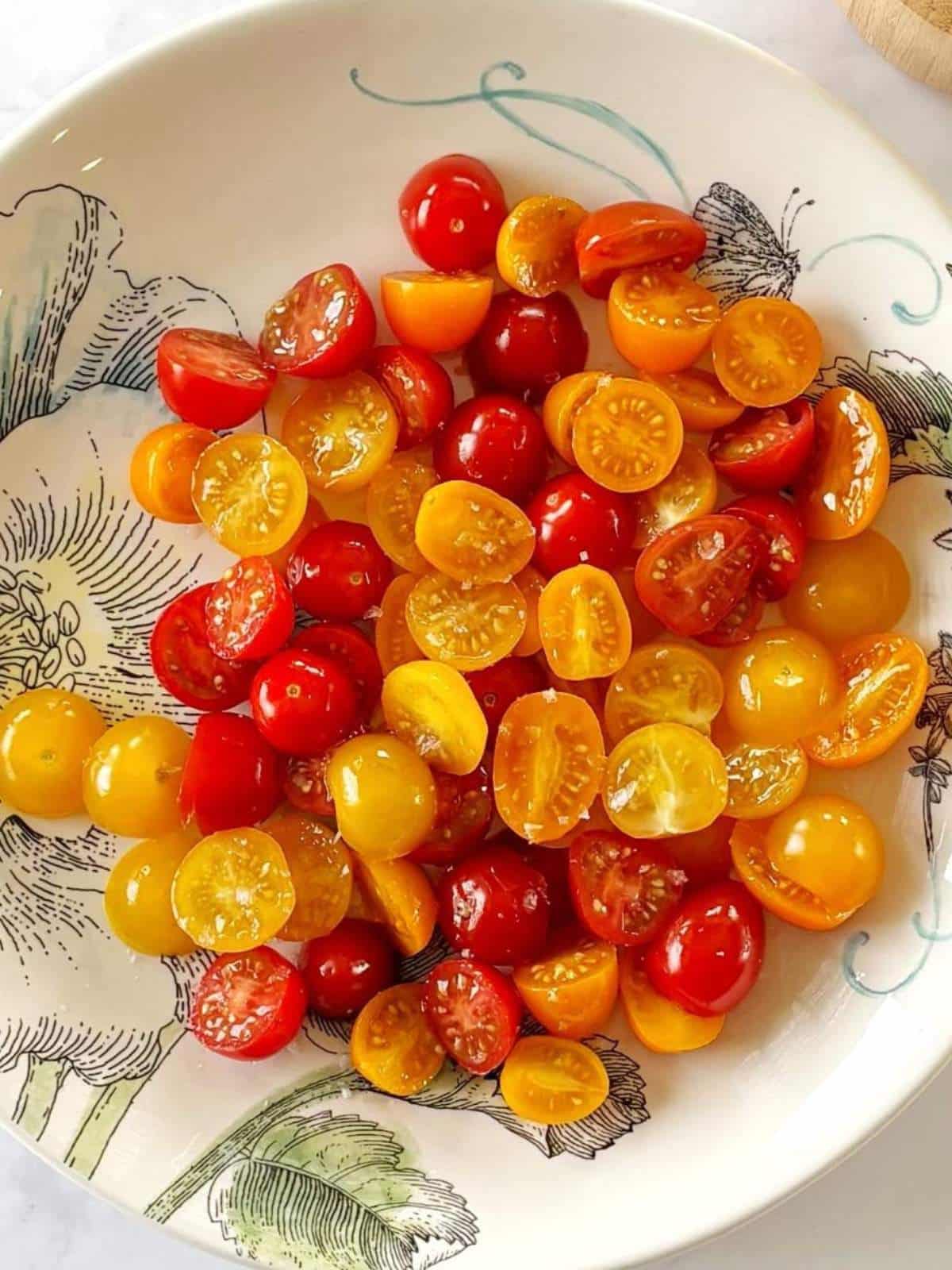 A serving platter wtih tomatoes topped with olive oil and salt.