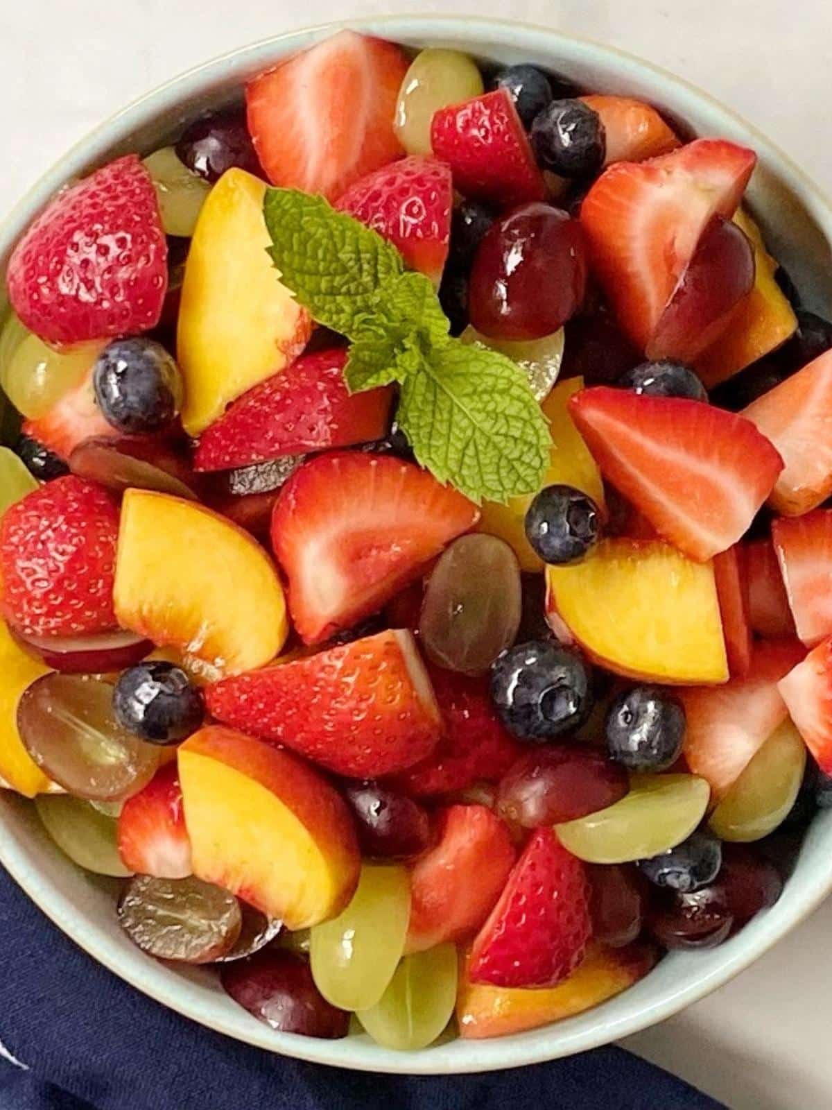 Fruit tossed with simple syrup in a serving bowl.