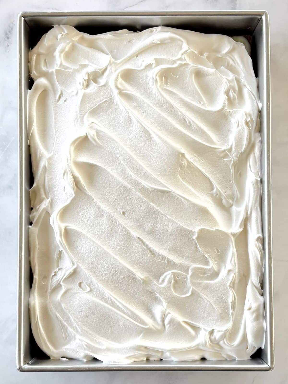 Cake topped with whipped topping.
