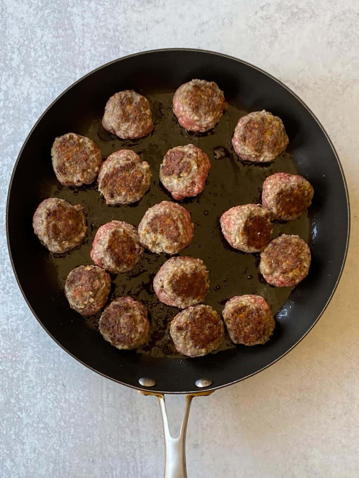 Browning the meatballs in a skillet.