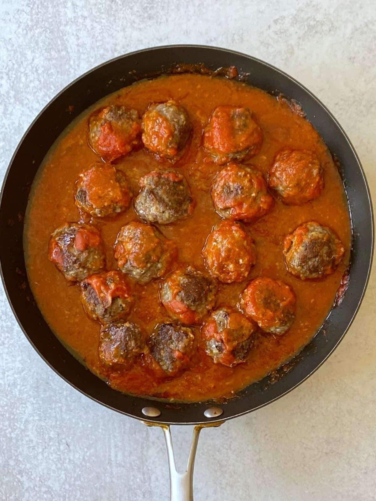 Meatballs with sauce in a skillet.