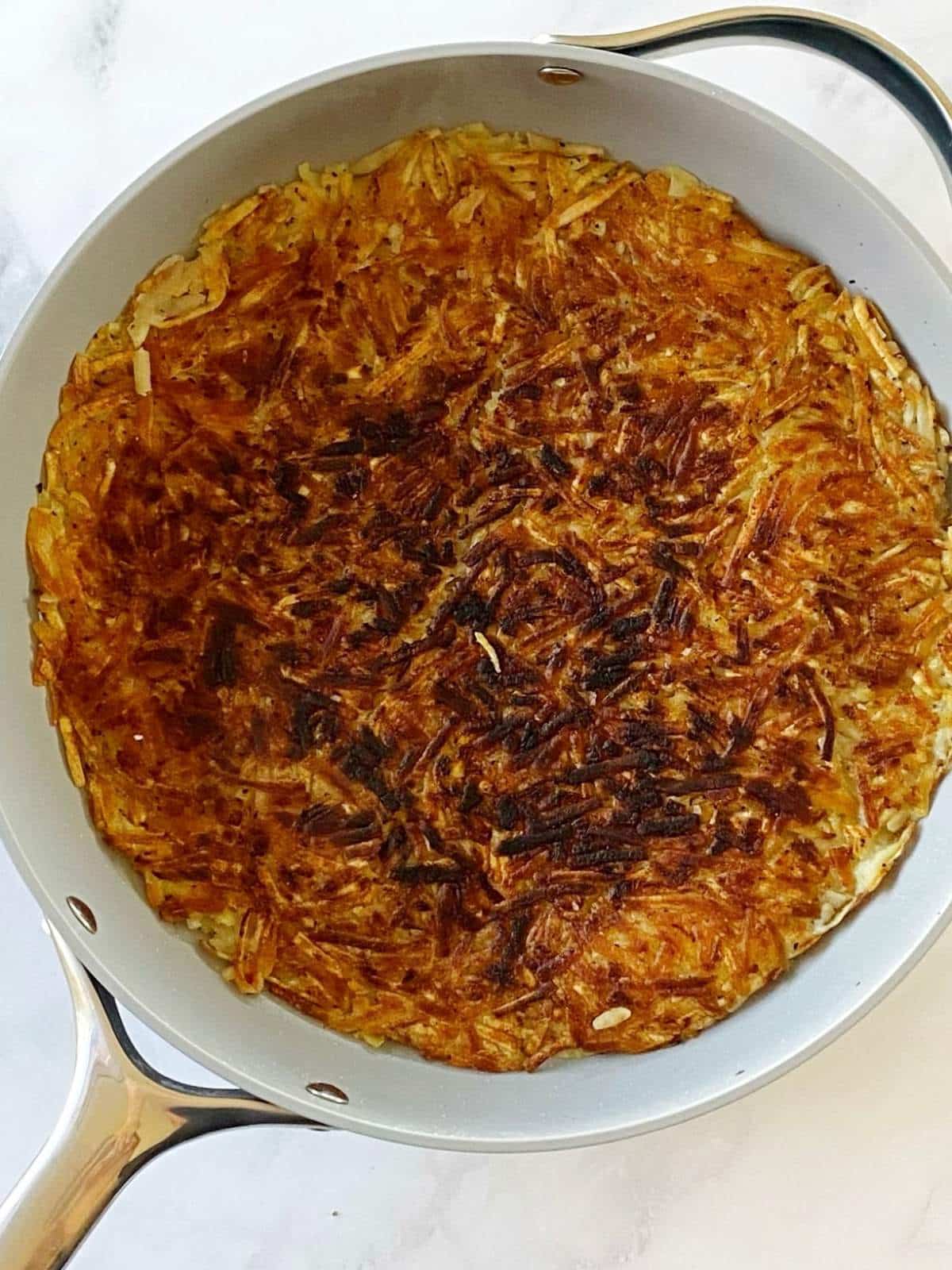 Cooking second side of hash browns in a skillet.