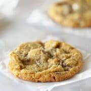 Cookie on a piece of parchment next to another cookie.