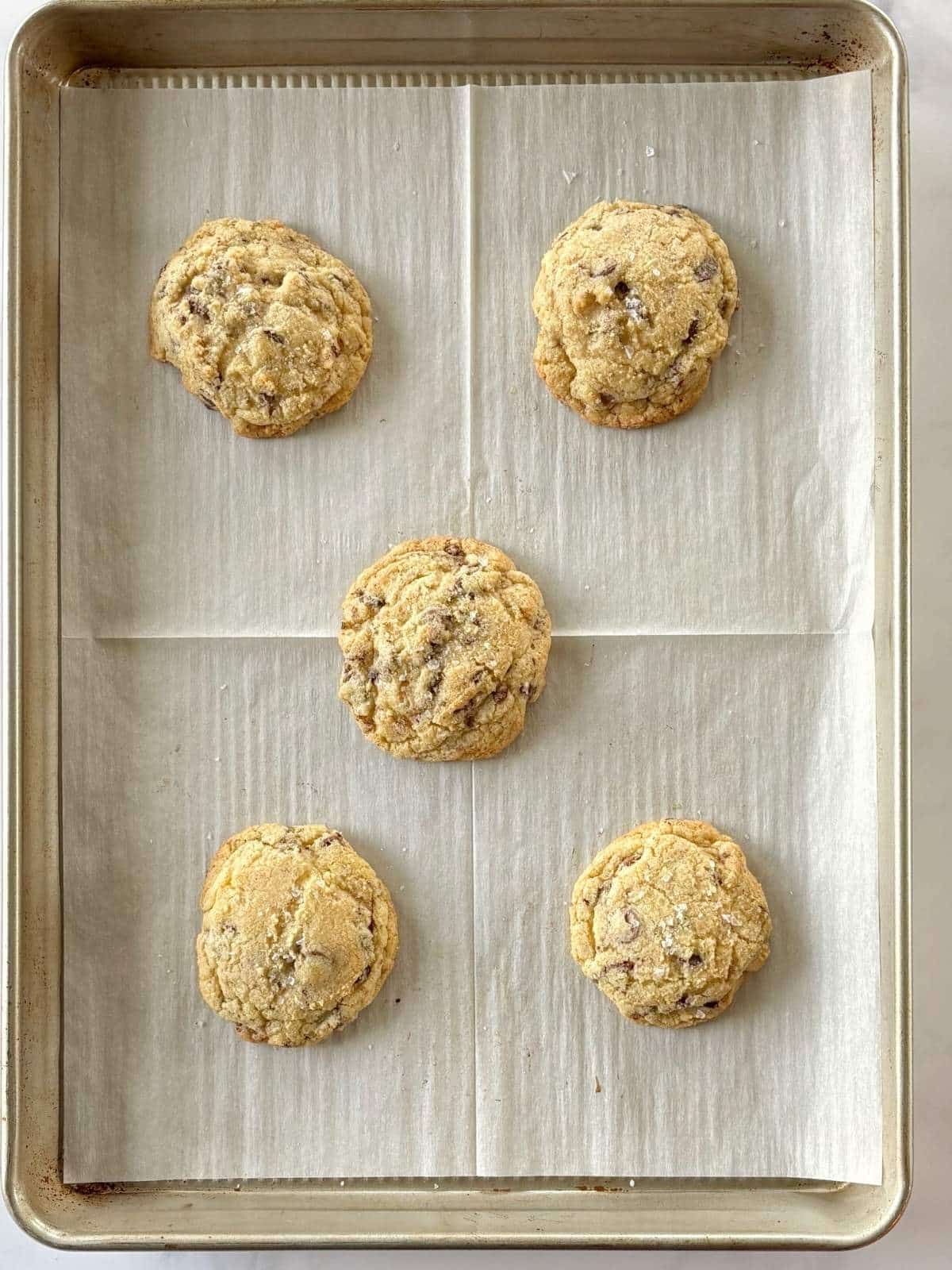 Baked cookies on a parchment-lined sheet pan.