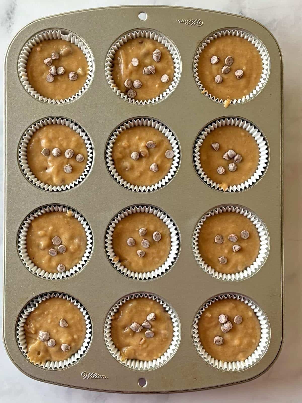 Batter portioned into paper-lined muffin pan.