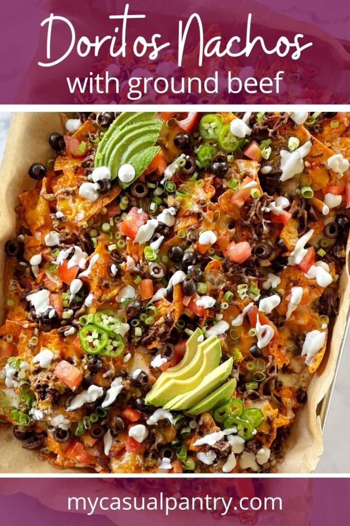 A sheet pan of nachos with a variety of toppings.