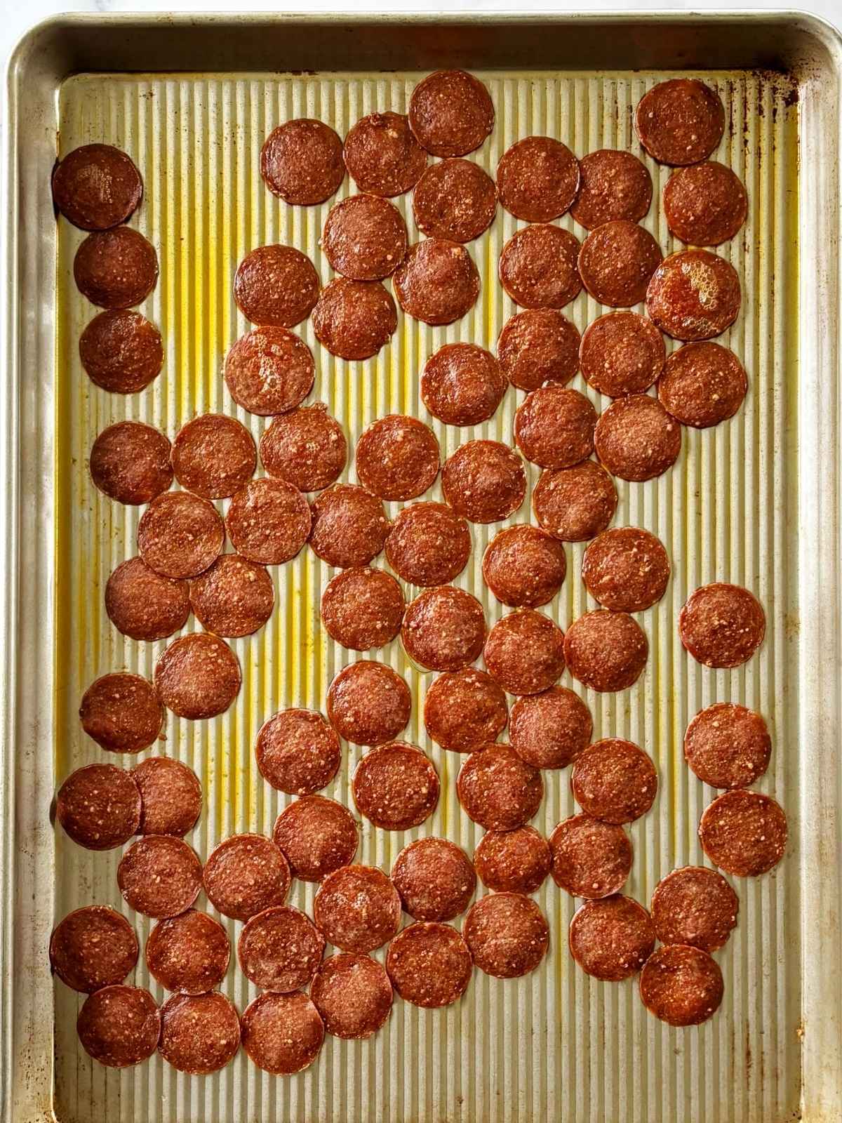 Baked pepperoni on a sheet pan.