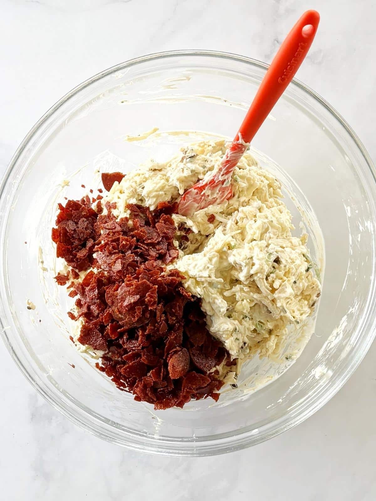 Adding the pepperoni to the cheese mixture in a mixing bowl.