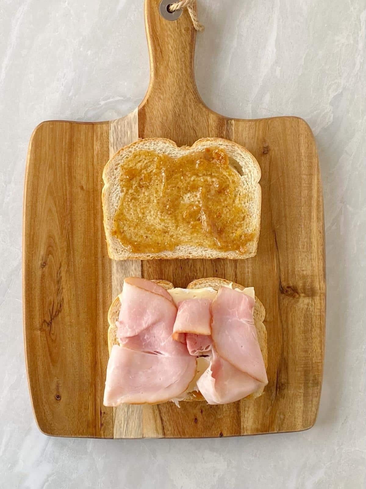Layering ham on the Brie sandwich.