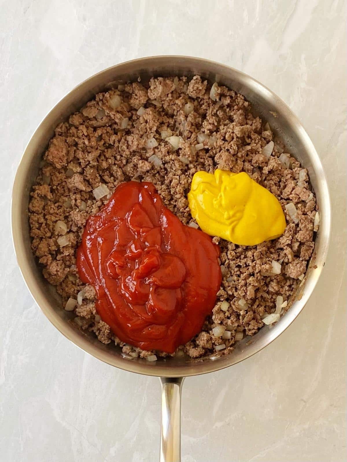 Ketchup and mustard added to the beef and onions.