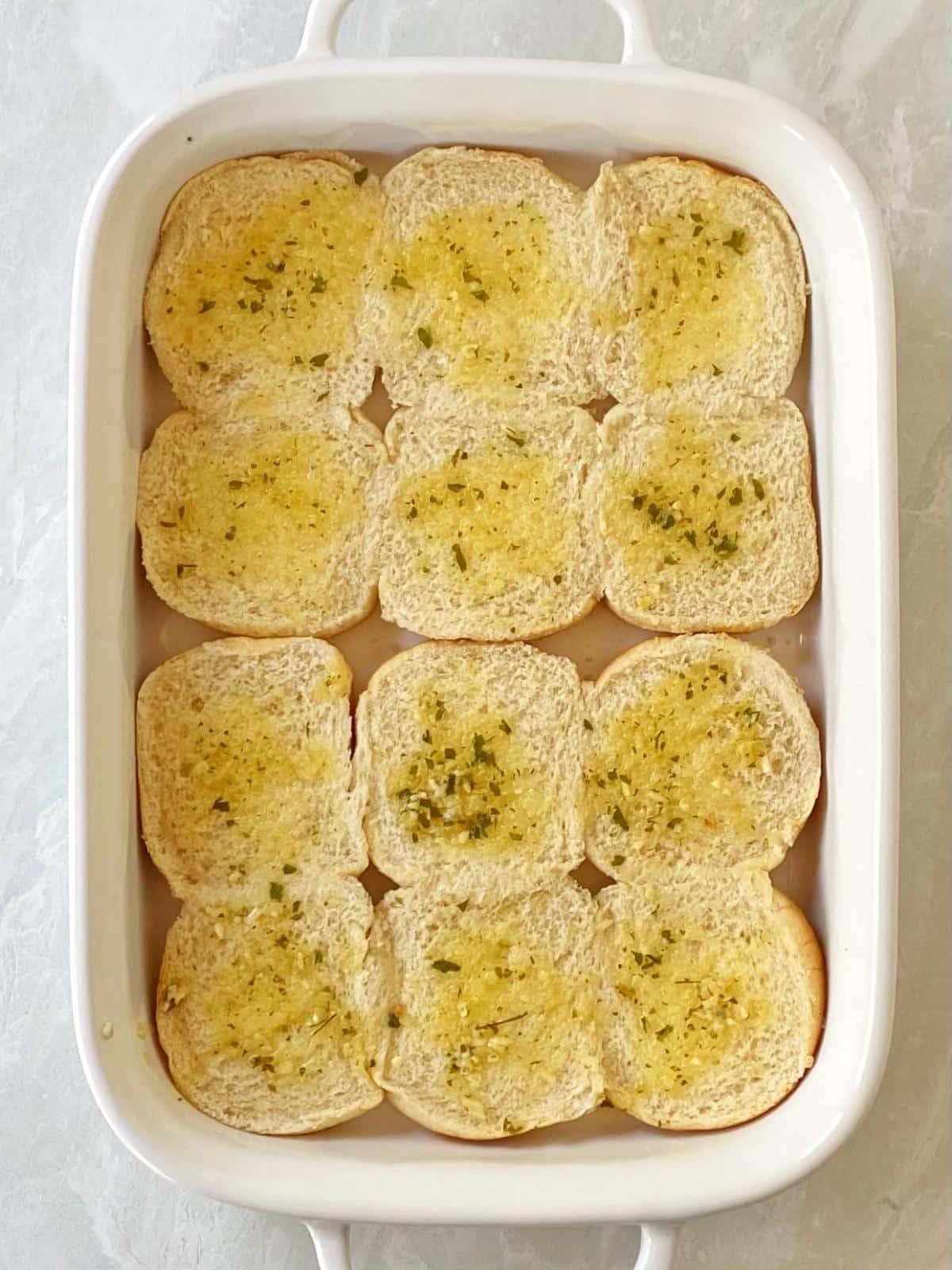 Building the sliders in a casserole dish with the bottom half of the buns in the bottom.