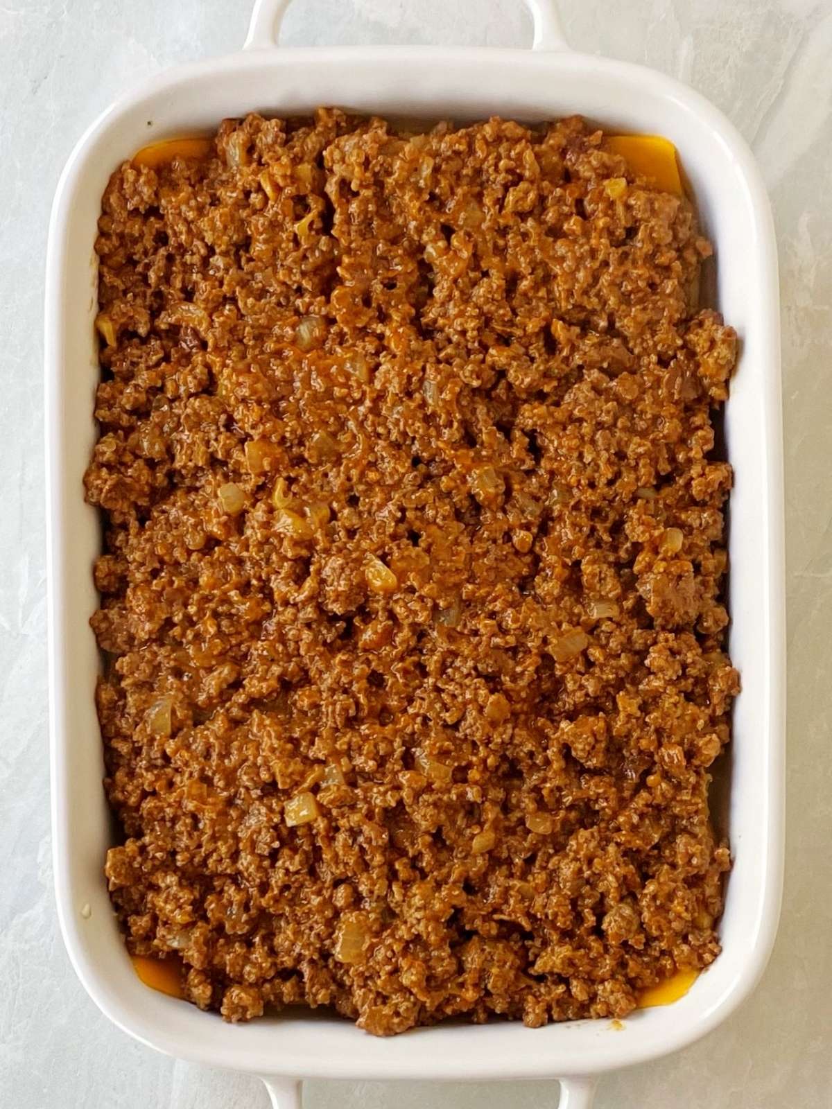 Layering the beef mixture over the cheese.