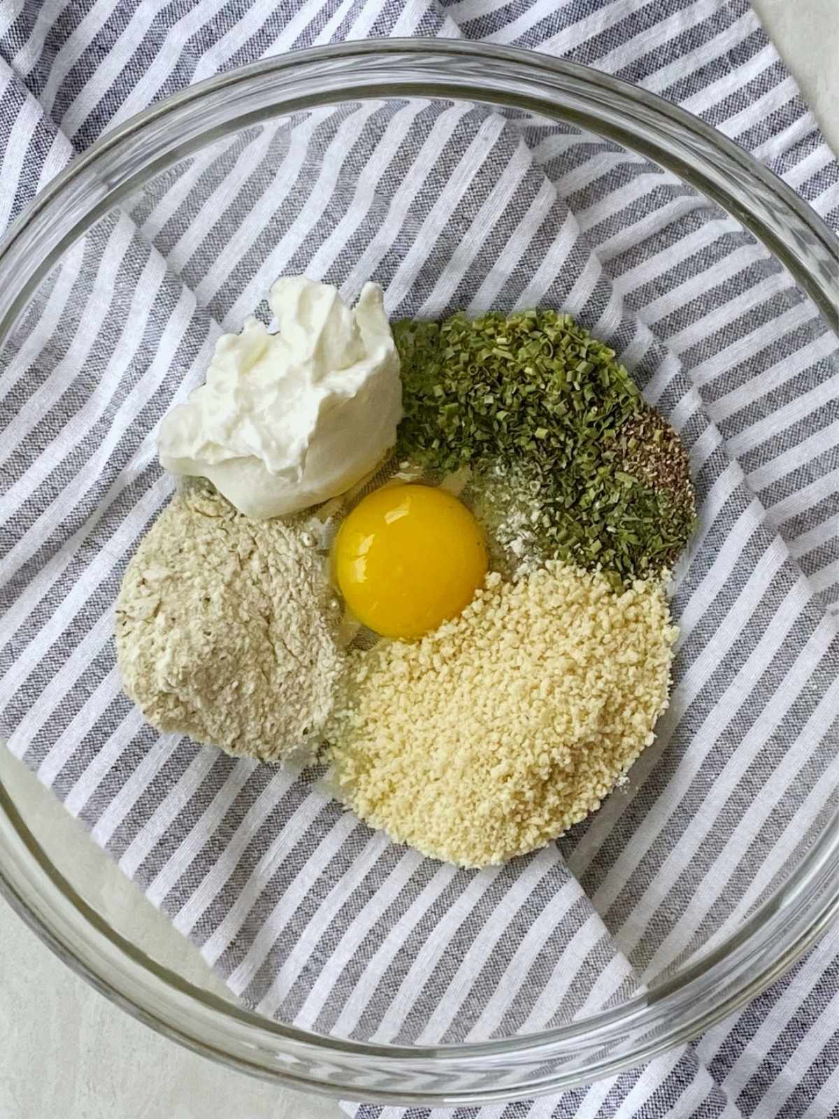 Egg, breadcrumbs, seasonings, and yogurt in a mixing bowl.