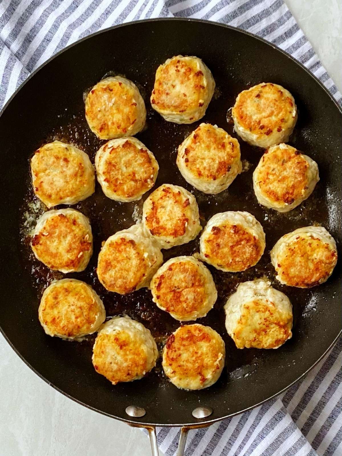 Browning meatballs in a skillet.